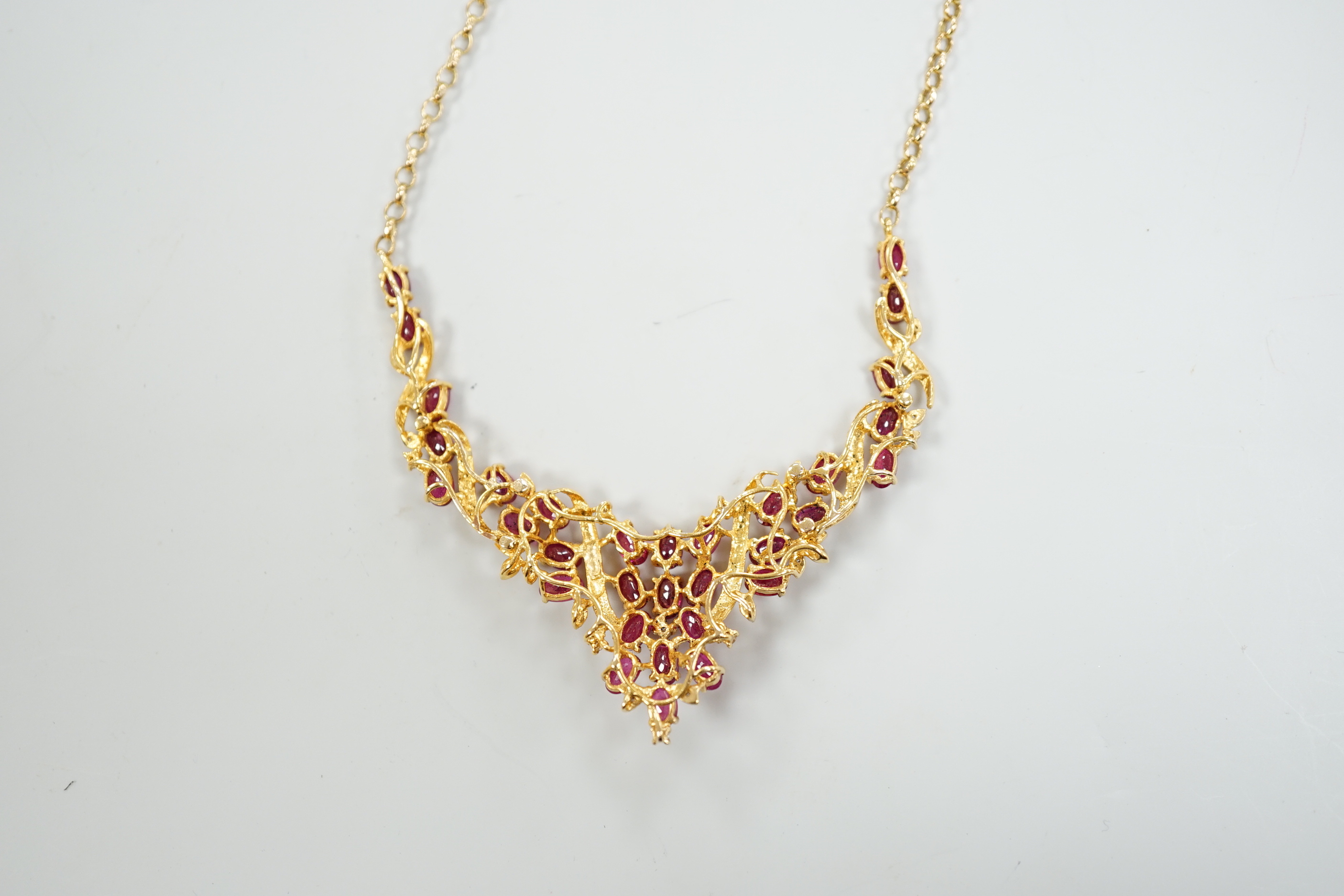 A 20th century Indian yellow metal, ruby and diamond chip cluster set necklace, with later 375 chain, 52cm, gross weight 12.2 grams.